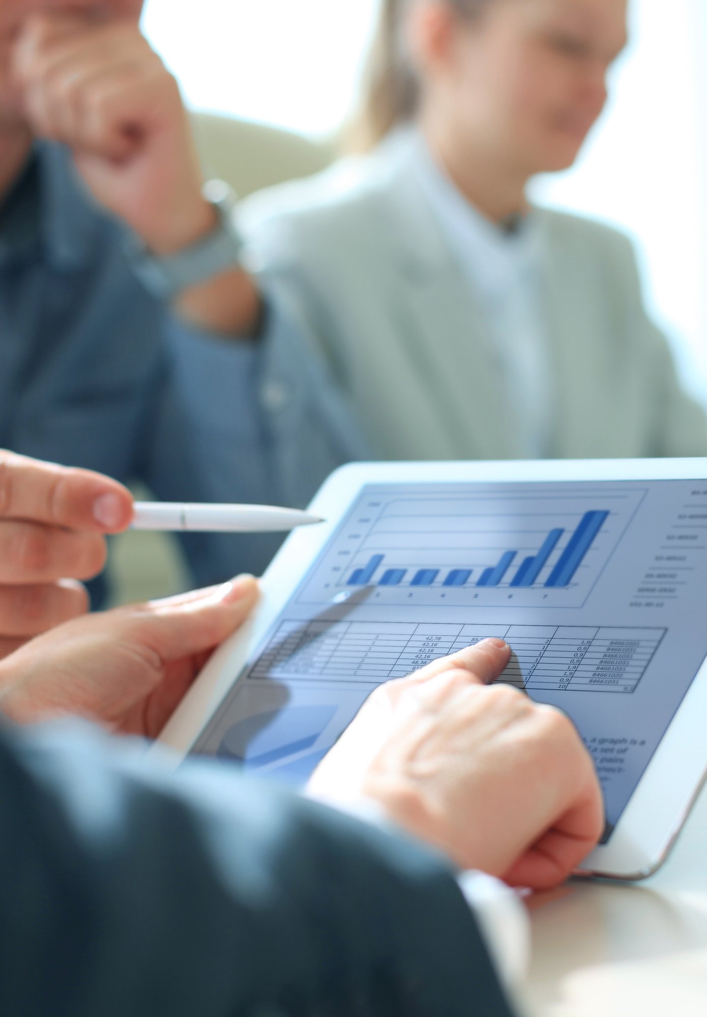 people pointing to data on a tablet