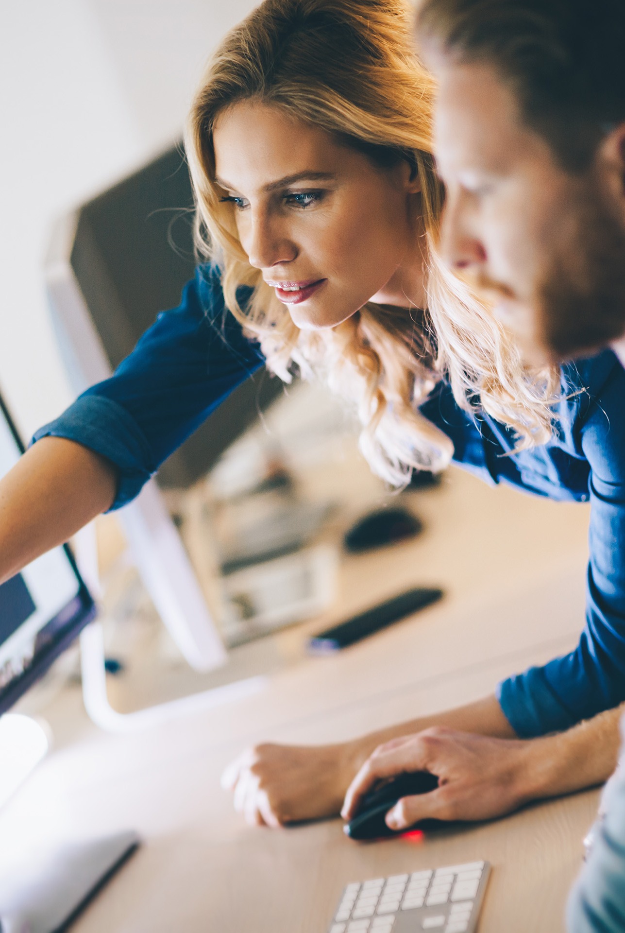 woman showing man something on computer